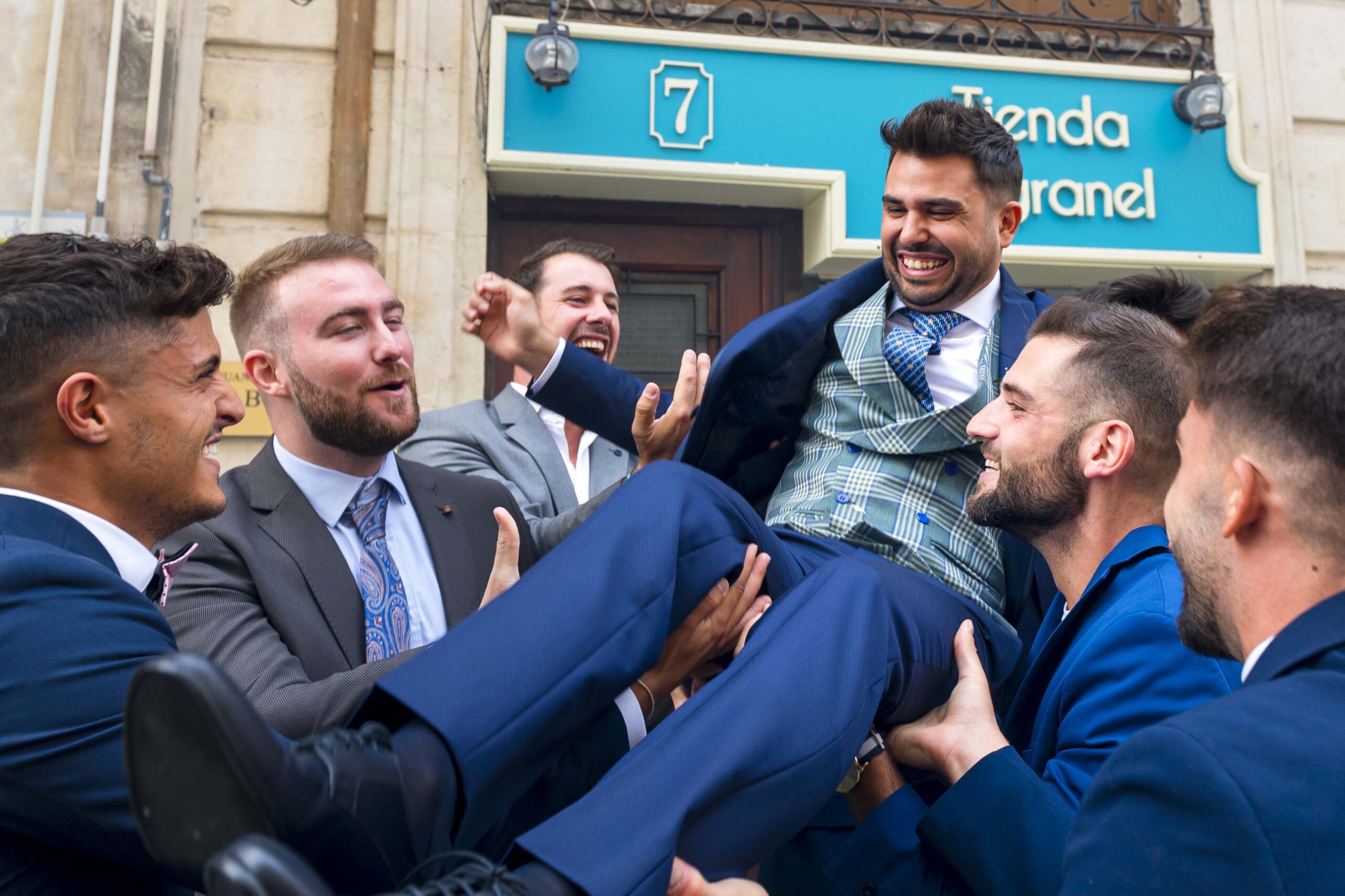 Boda en Alcoy, novio en brazos de sus amigos Novio-siendo-manteado-por-sus-amigos-a-la-hora-de-salir-de-casa-hacia-su-boda